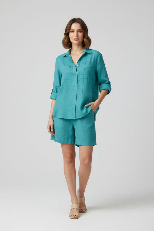 Teal shirt and shorts set on hangers against a dark background